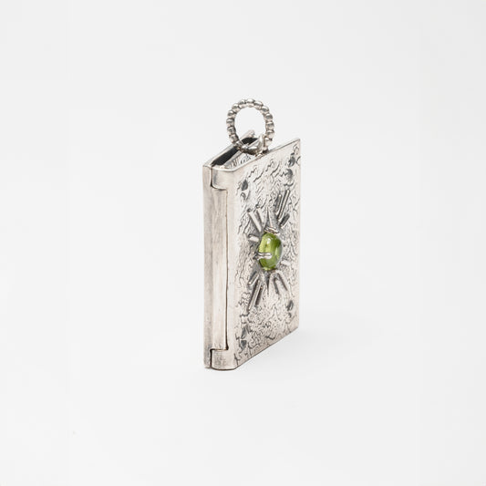 Primo piano del pendente “Libro” in argento brunito, con focus sul dorso scolpito e sulla texture lucida della copertina – design fatto a mano