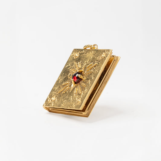 Dettaglio pendente libro porta foto con granato rosso – design raffinato in oro, ispirato alla memoria e all’amore eterno