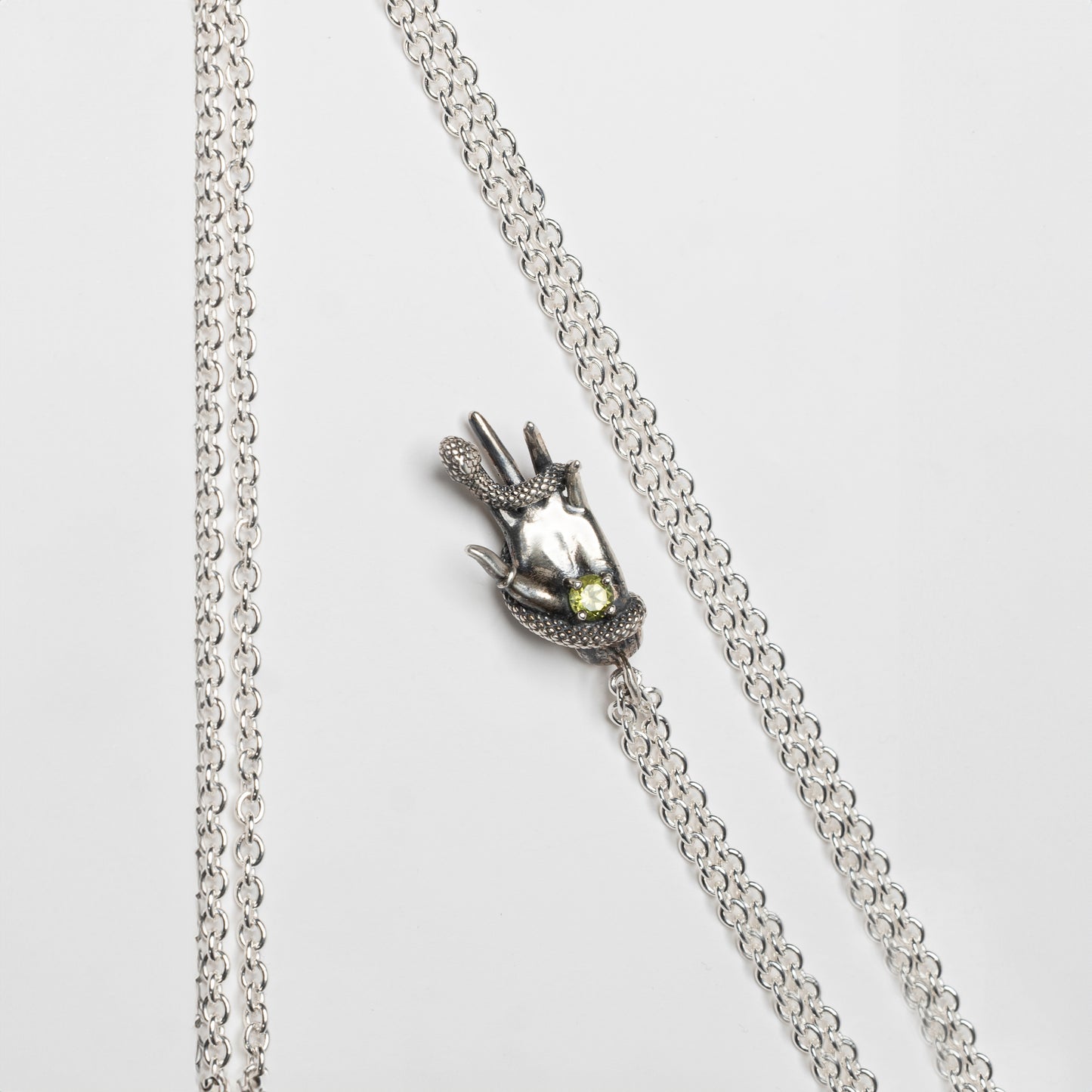 DESIDERIO - pendente mano con serpente e pietra peridot verde
